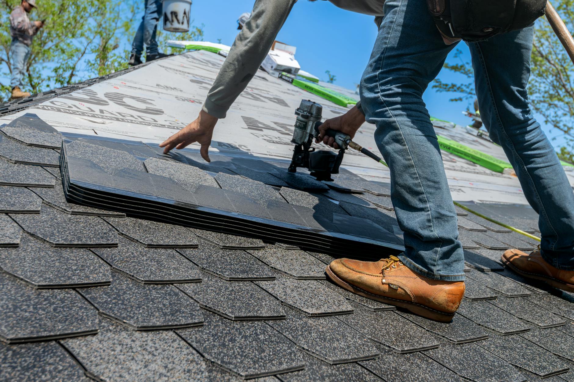 Professional roofing crew installing architectural composition shingles on a commercial building in Henderson, NV.